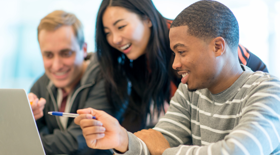 Three student looking at computer